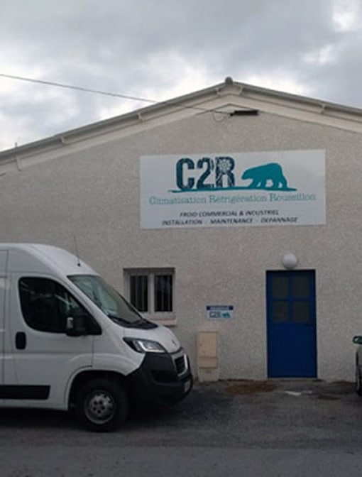 Bâtiment C2R Climatisation Réfrigération Roussillon avec logo ours polaire. Froid commercial, installation, maintenance, dépannage. Van blanc.